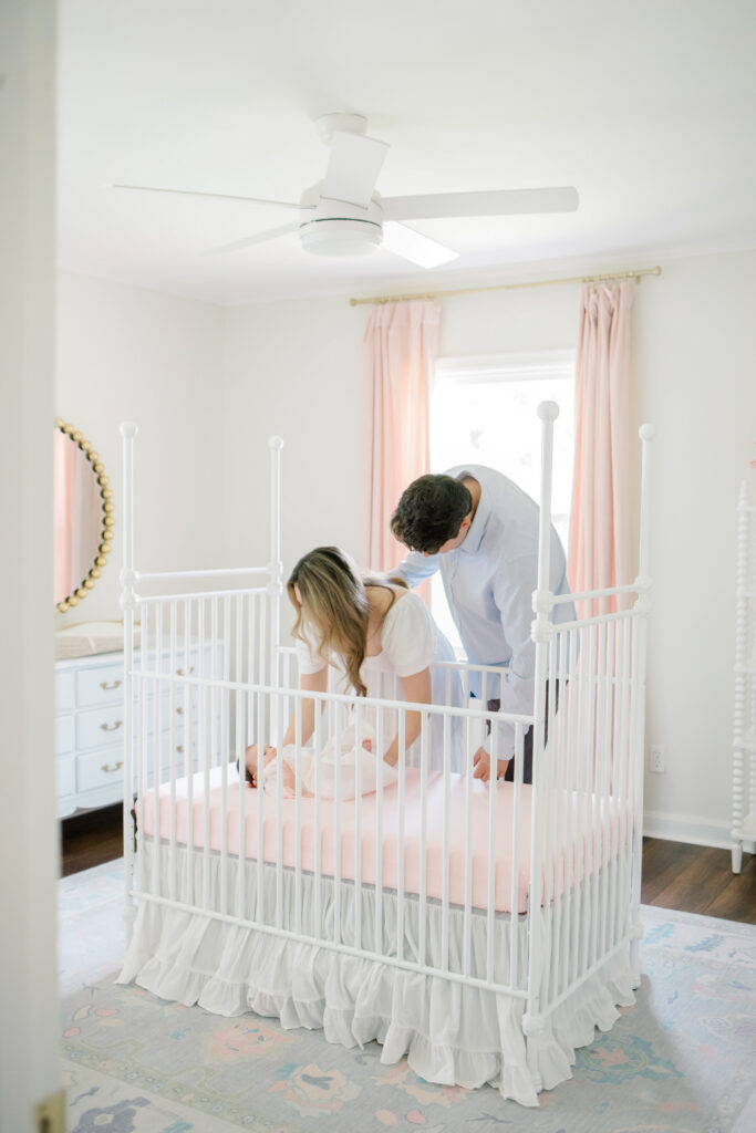 Parents standing beside their baby's crib during an in-home newborn session in Memphis