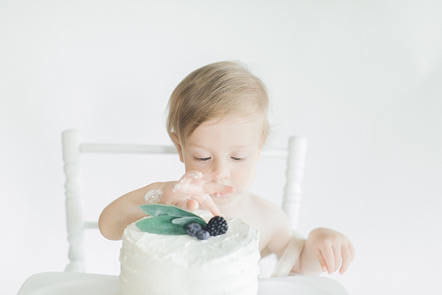 Baby boy touching frosting on cake