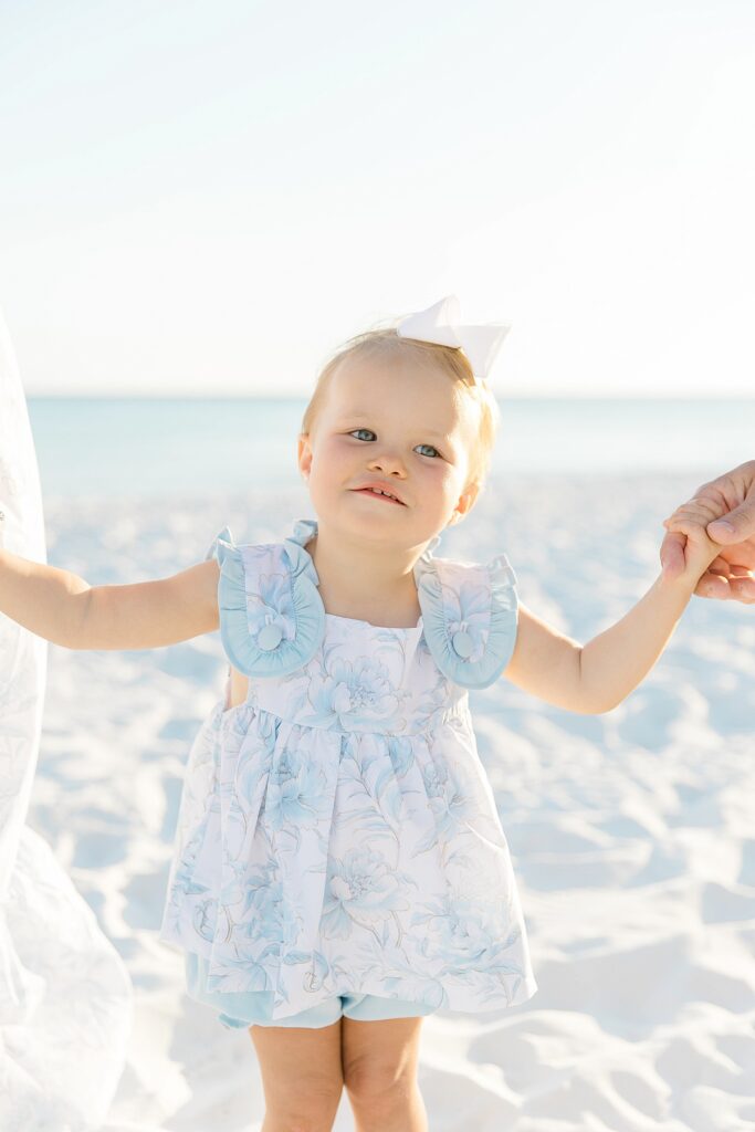 A little girl playfully interacting with her parents on Destin beach