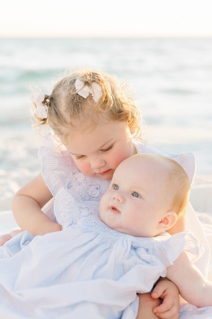 Two little girls on Destin beach with the baby in the toddler's lap