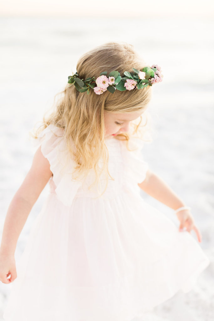 little girl with a flower crown on the beach